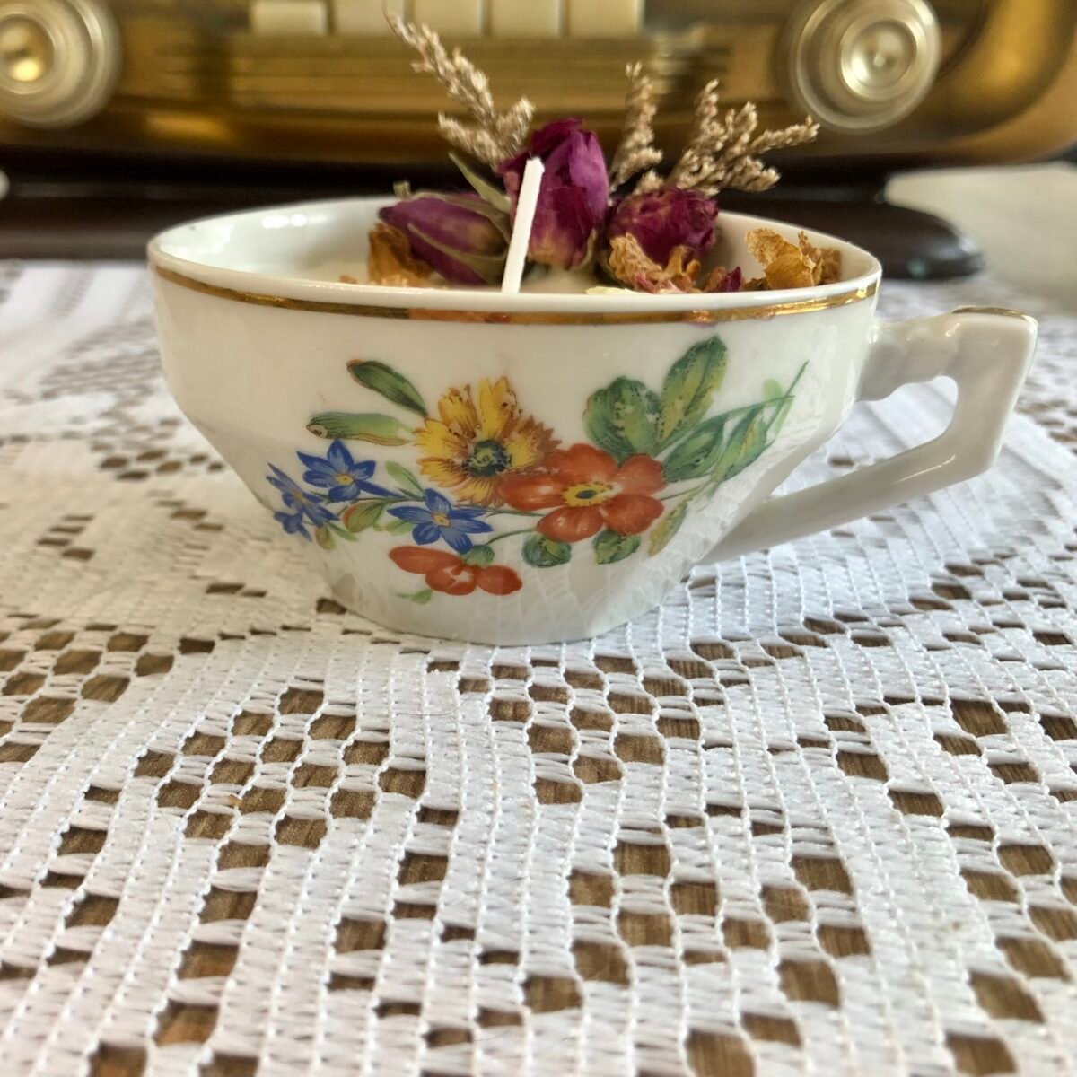 Bougie artisanale dans une petite tasse à thé vintage blanche et liseré doré avec fleurs séchées dans les tons naturels