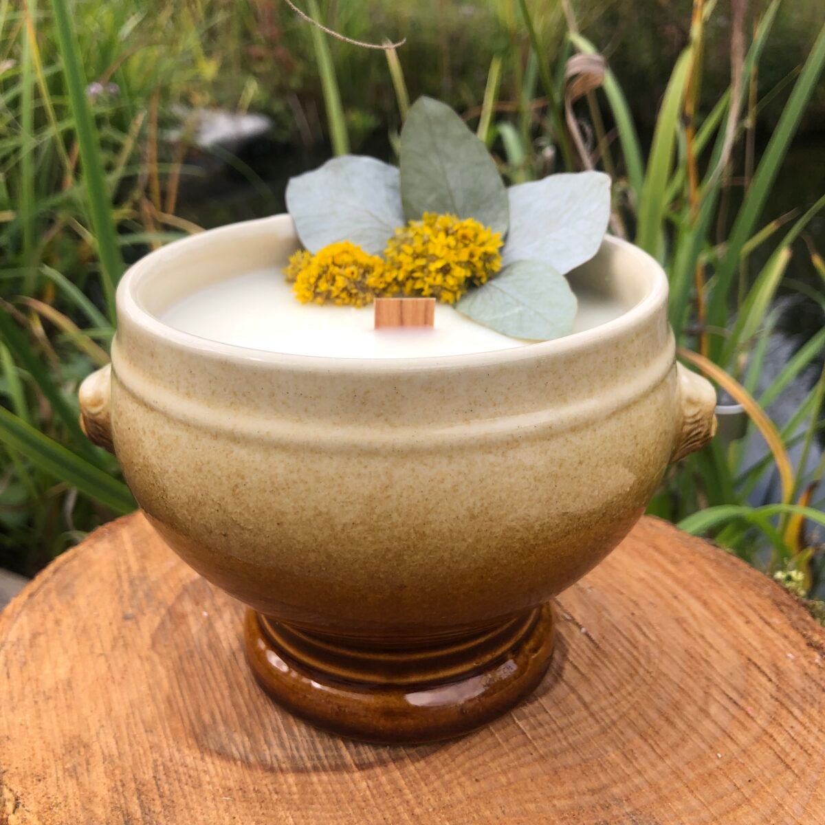 Bougie artisanale dans un grand pot vintage de style terrine avec des fleurs séchées jaune et eucalyptus